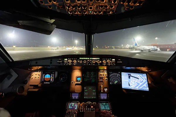 Airplane cockpit inside view at night with Lido AMM running on screen
