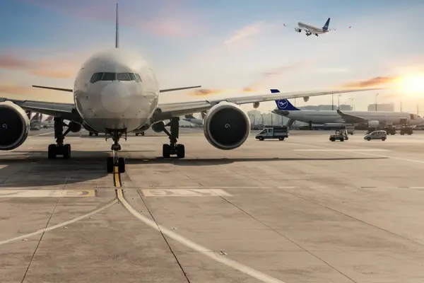 Airplane at the airport with a sunset in the background