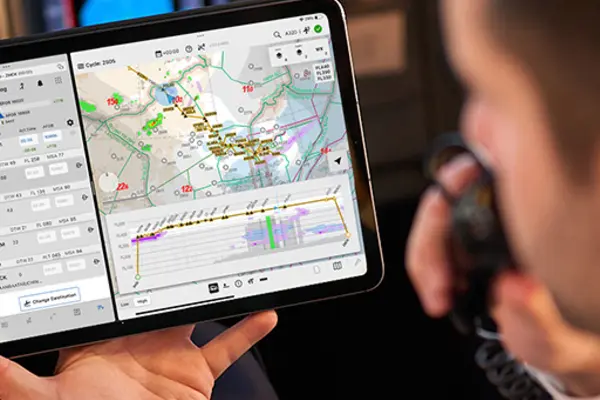 Pilot in cockpit holding iPad