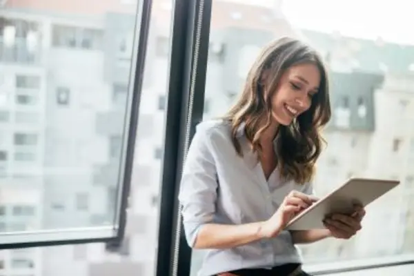 Person using a tablet near a window in a modern office.