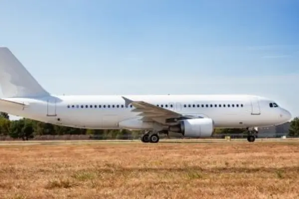 White passenger airplane on the runway in sunny weather