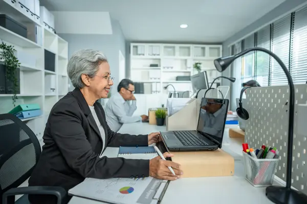 Workspace with laptop, documents, and desk lamp in a modern office