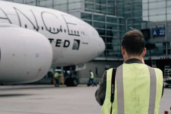 Man standing on the tarmac in front of an airplane