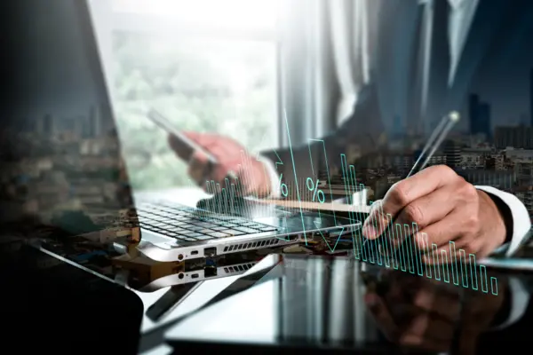 A businessperson using a digital tablet to conduct productive business while monitoring quality control growth