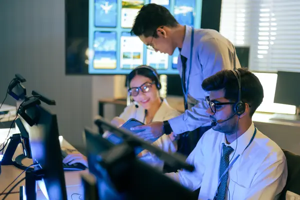 Team in an operations center using headsets and monitoring systems with digital dashboards