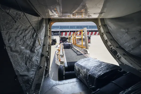 Luggage loaded into an aircraft cargo hold via a conveyor belt