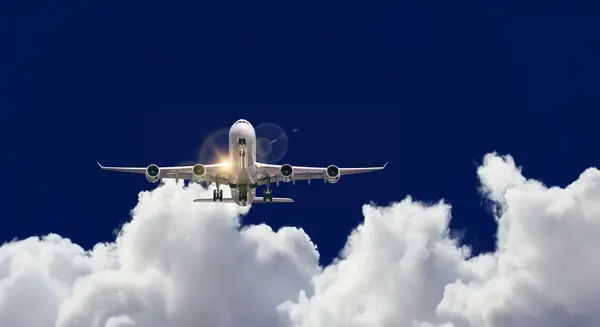 Passagierflugzeug fliegt durch Wolken vor blauem Himmel