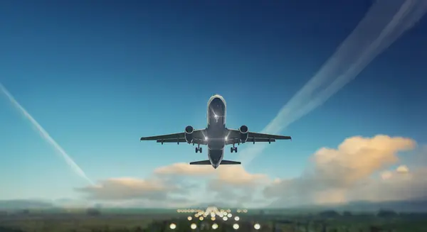 Commercial aircraft taking off above the runway under a clear blue sky