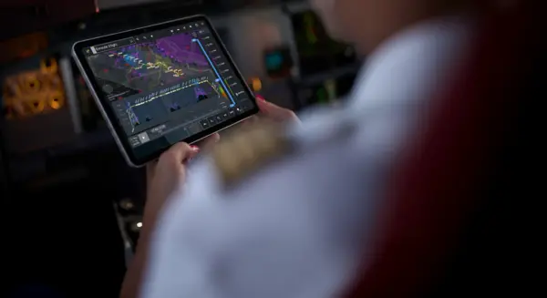 Tablet displays enroute flight map with route, weather data, and altitude profile