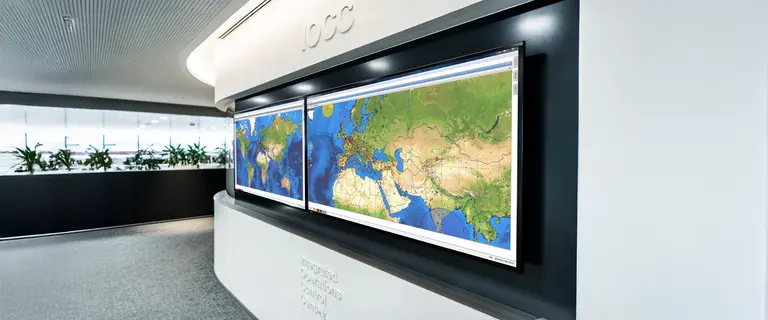 Large world map displays in an airline operations center for flight monitoring