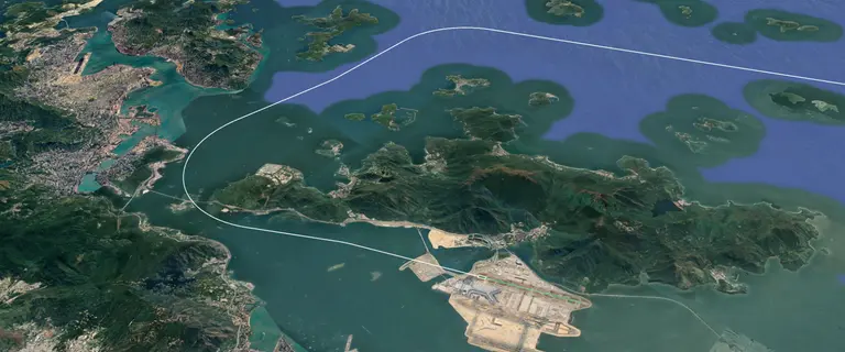 Aerial view of an airport with a visualized approach or departure path over coastal and mountainous terrain.