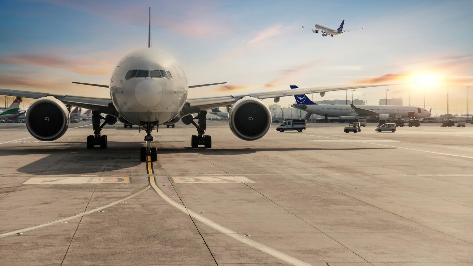 Airplane at the airport with a sunset in the background