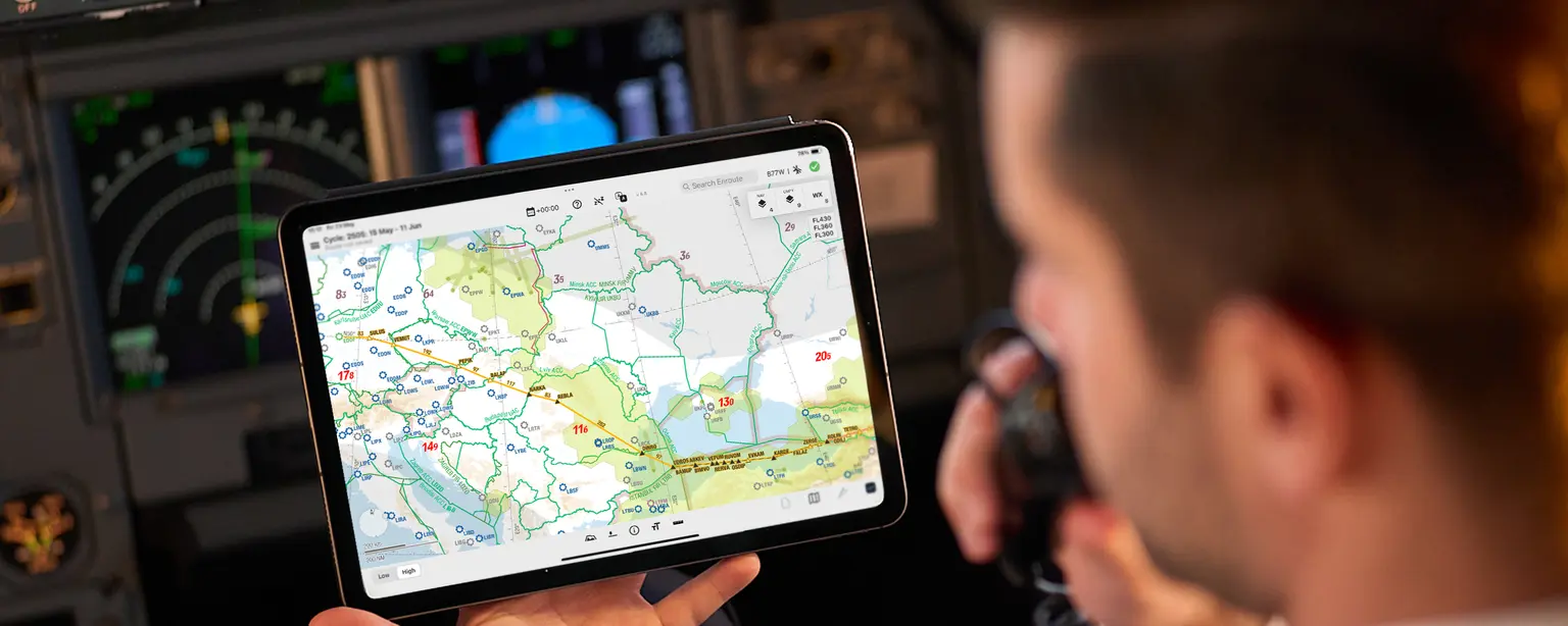 Pilot holding a device which is showing navigation solution Lido mPilot
