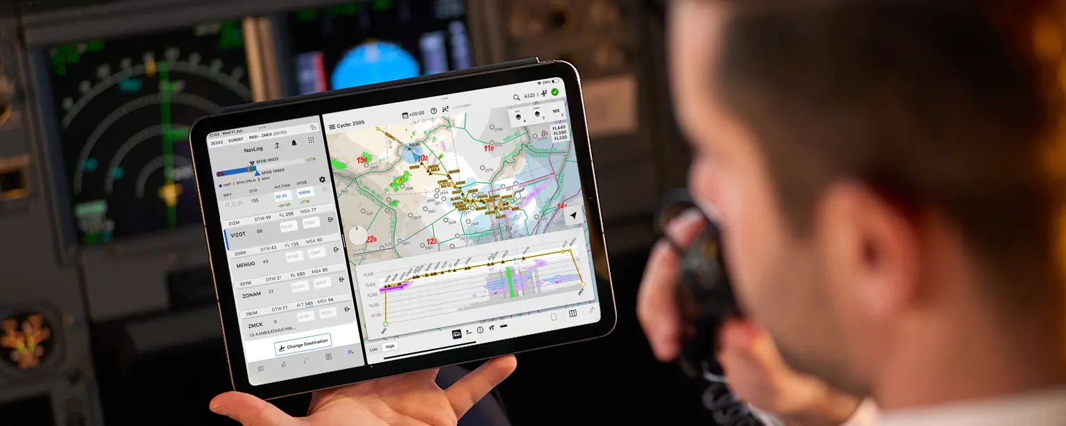 pilot holding iPad with navigation information in cockpit