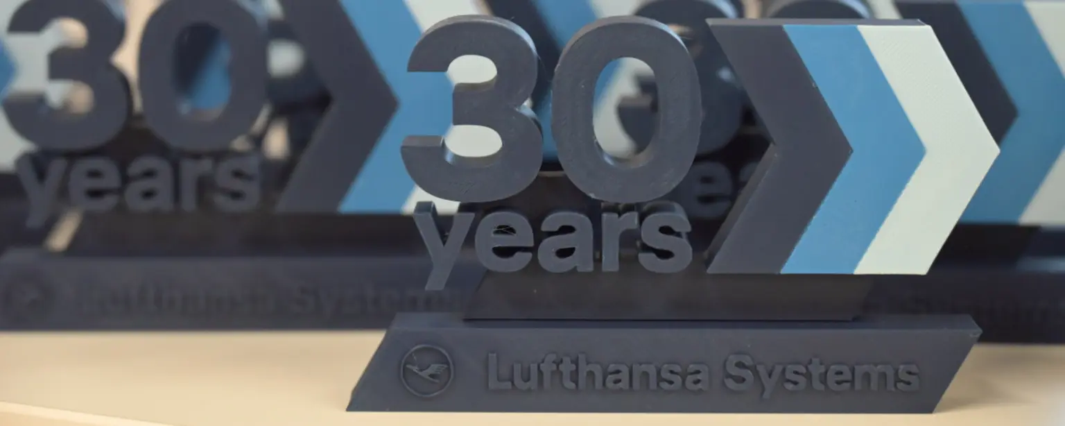 Design-Objekt mit der Aufschrift ‚30 Jahre‘ und Lufthansa Systems Logo – Symbol für Unternehmensjubiläum