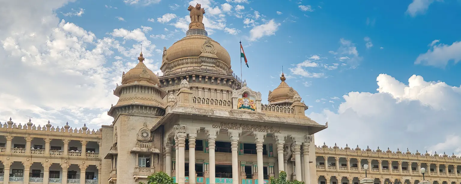Vidhana Soudha government building in Bengaluru, India, with blue sky and lush gardens