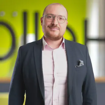Alexander Motzek from zeroG in business attire in a modern corporate environment